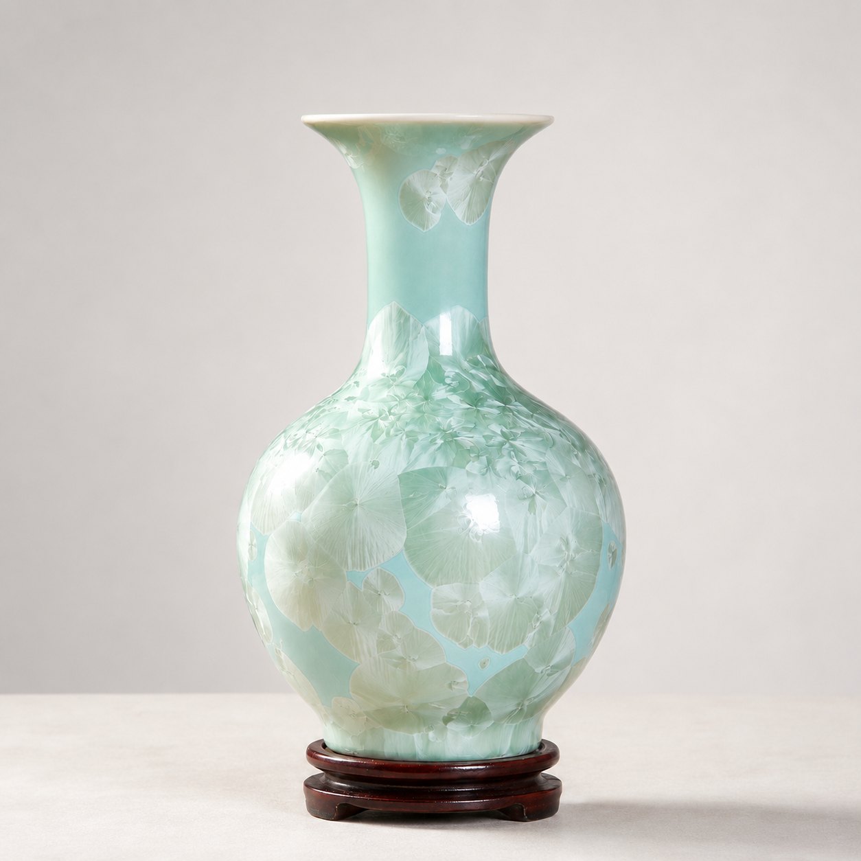 Celadon crystalline glaze ceramic vase on a wooden base