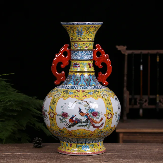 A yellow-ground vase has red double handles framing multicolor floral and bird panels