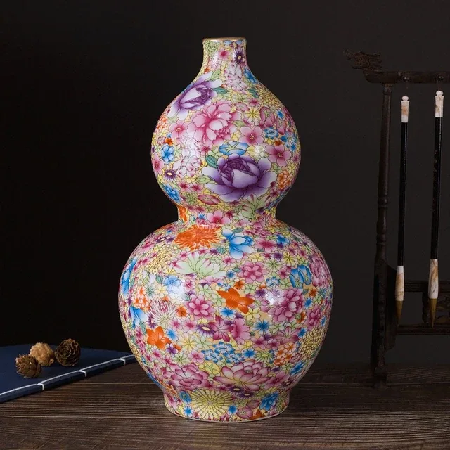 A double-gourd vase is covered with multicolor flowers, including prominent purple blooms