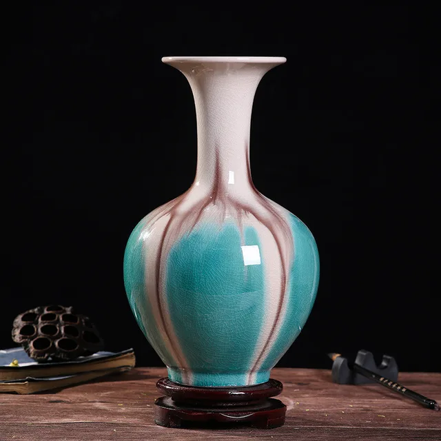 The pictured vase has a long neck and turquoise, cream and pink bands flowing down its body