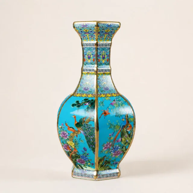 A hexagonal vase carries floral and bird panels against a bright turquoise ground