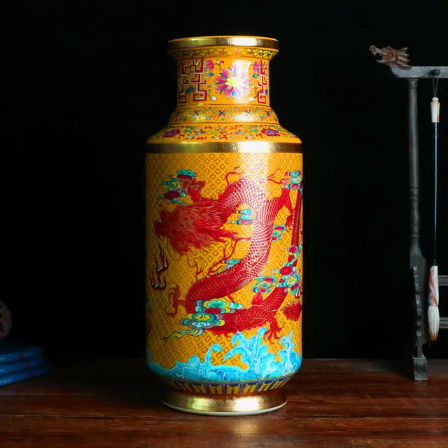 The pictured cylindrical vase has twin red dragons on a yellow ground with blue accents