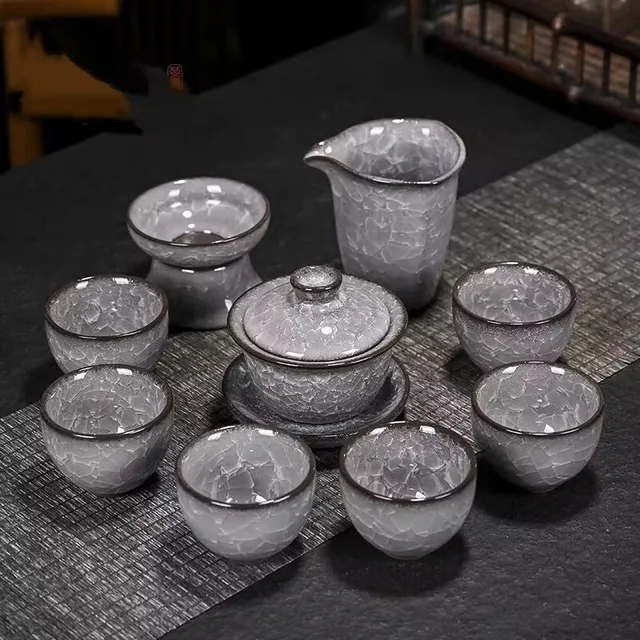 The pictured grey crackle-patterned tea set includes a lidded gaiwan and coordinating tea vessels