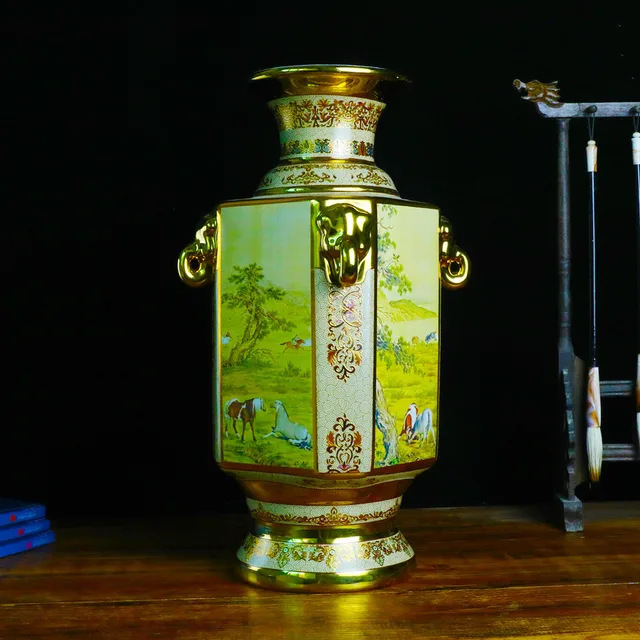 A faceted vase has horse-themed panels, elephant-shaped handles and gold-tone details