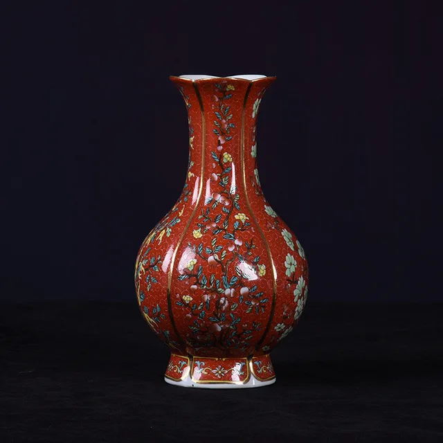 The pictured vase has a red ground, a flared rim and small floral motifs across its rounded body