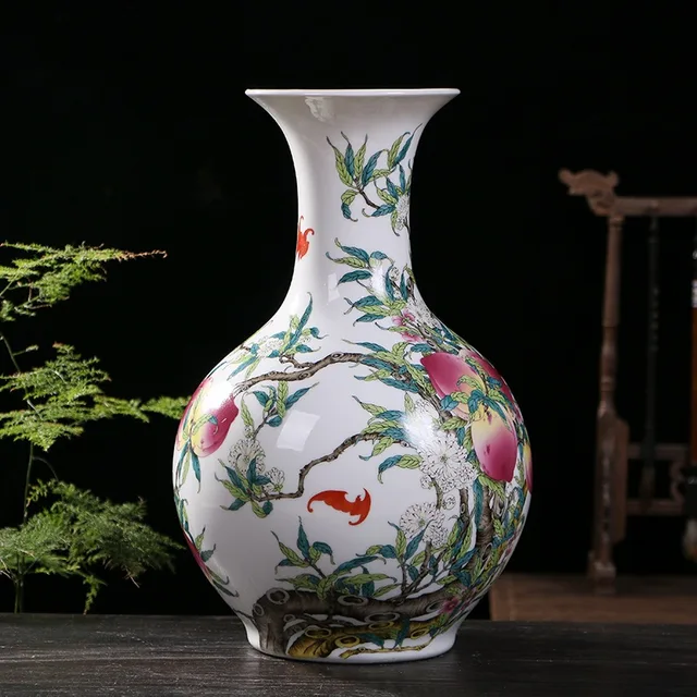 Peaches, leafy branches and birds decorate the white ground of a rounded, flared-neck vase