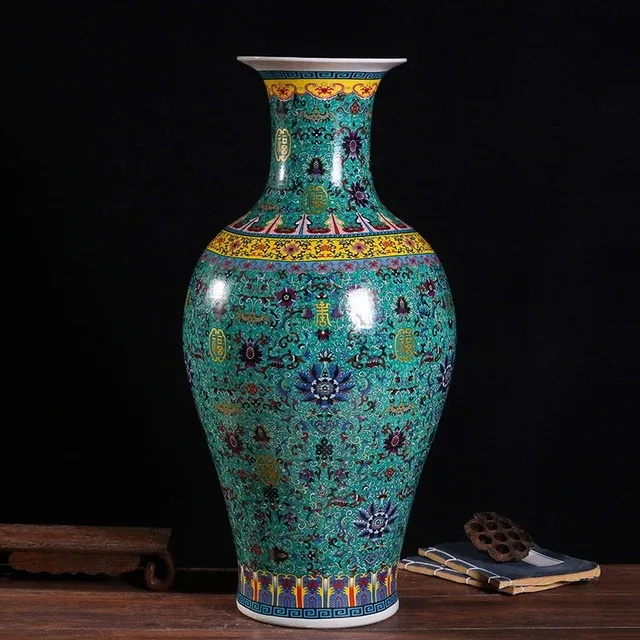 A tall turquoise-ground vase has dense floral decoration and contrasting gold-tone borders