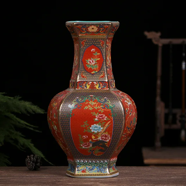 The pictured hexagonal vase has red floral panels framed by green and gold-tone borders